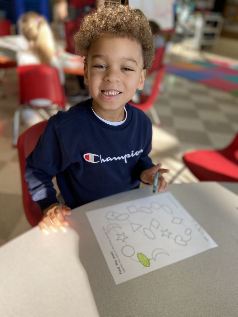 School-age boy coloring a picture at The Club House childcare center.
