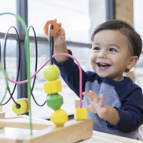 Smiling toddler at The Club House childcare center in Oakdale, Farmington or Rosemount, MN.